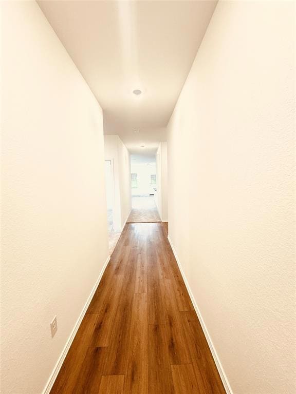 Corridor featuring wood finished floors and baseboards