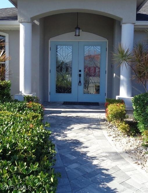 Property entrance with french doors and stucco sid