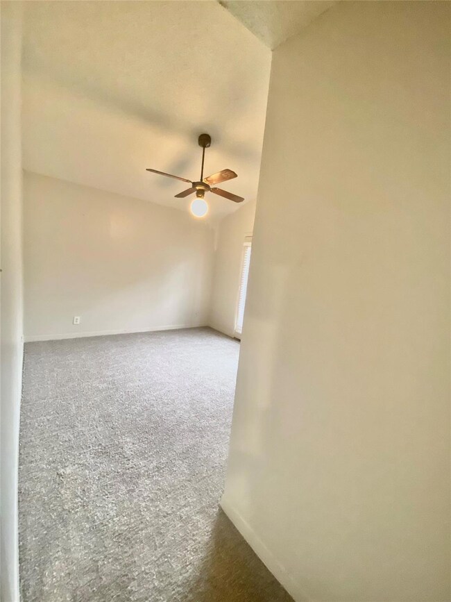 Spare room featuring a ceiling fan, carpet floori