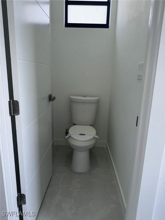 Bathroom featuring toilet and baseboards