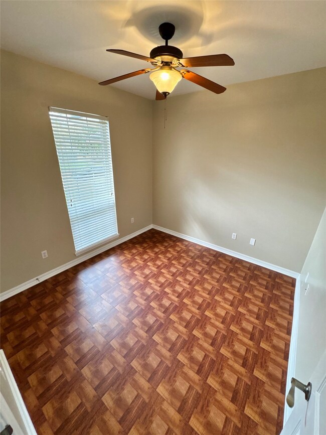 Empty room featuring baseboards and a ceiling fan