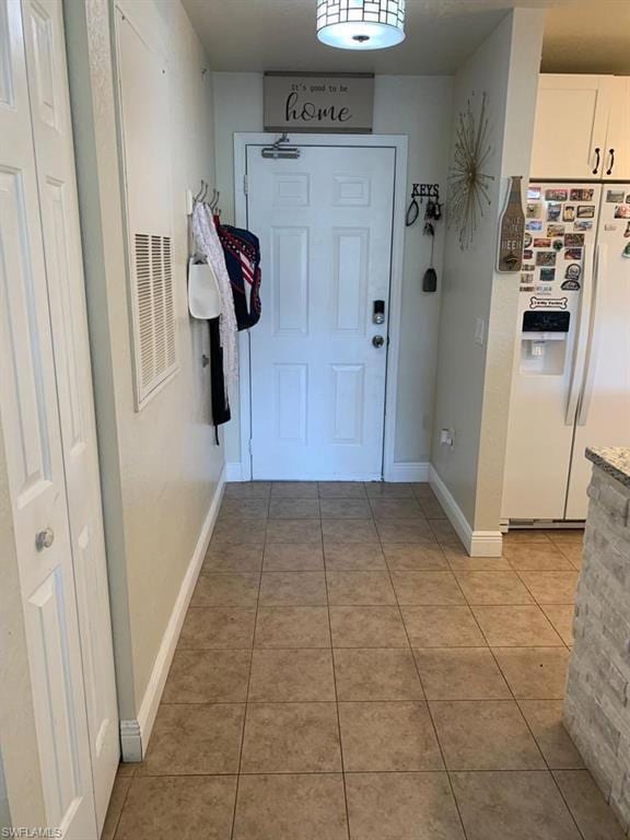 Doorway featuring tile patterned floors and baseboards