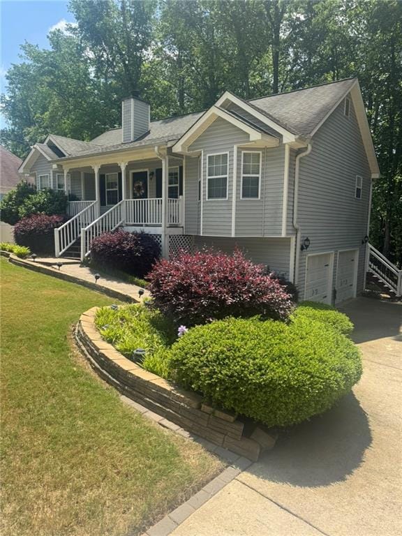 Ranch-style house with a chimney, an attached garage, stairs, driveway, and a porch