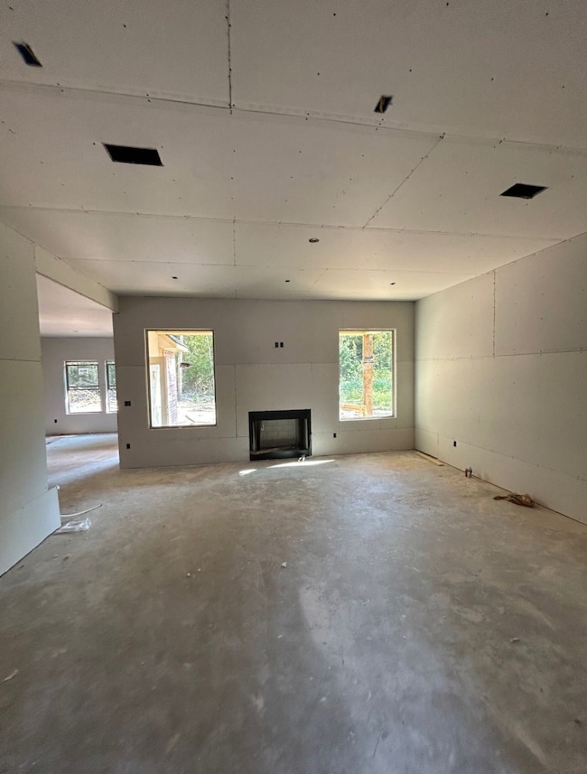 Unfurnished living room with a fireplace and concrete floors