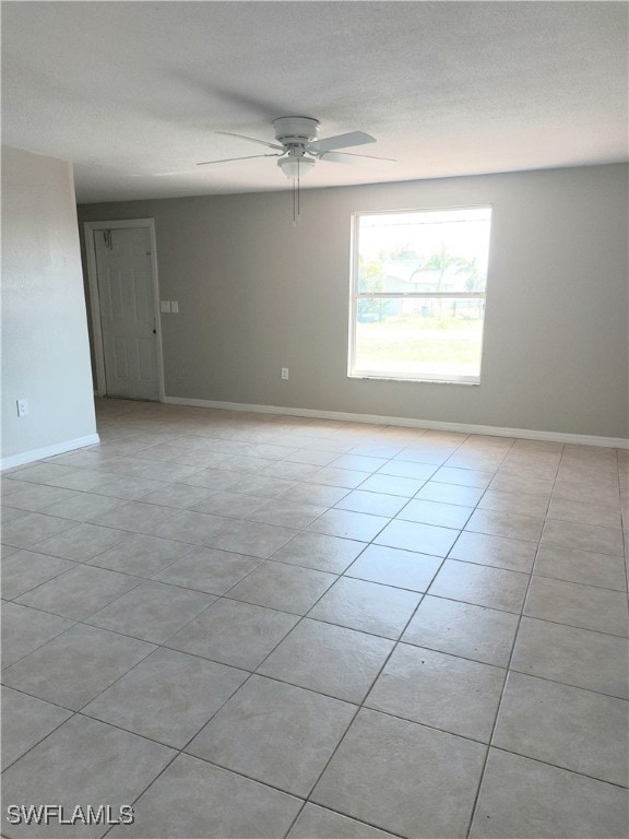 Spare room with a ceiling fan, light tile patterne