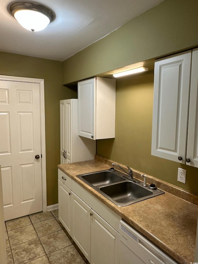 Kitchen with light tile patterned floors, dishwash