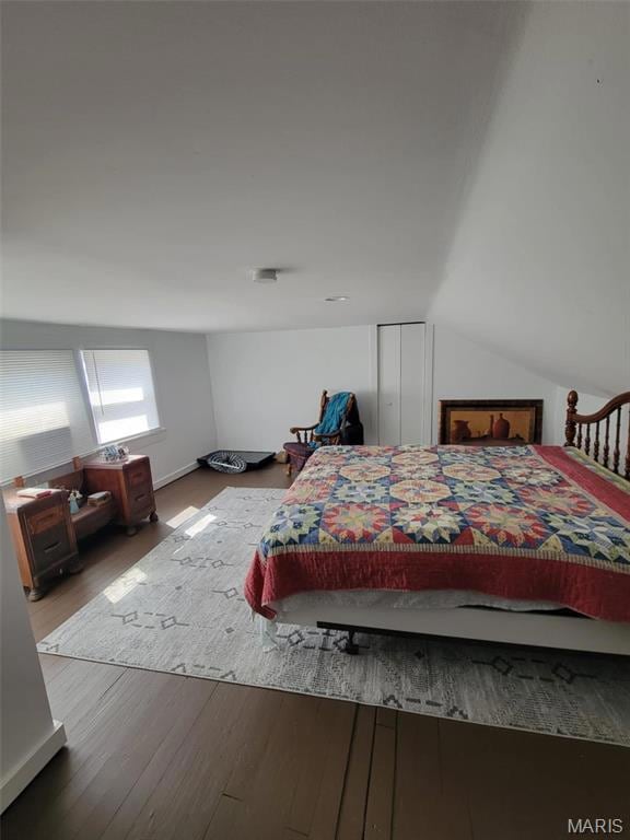 Bedroom featuring vaulted ceiling and wood finished floors