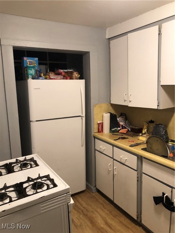 Kitchen featuring white appliances, light countertops, dark wood finished floors, white cabinetry, and gray cabinetry