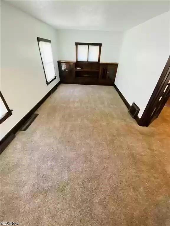 Unfurnished living room with light colored carpet