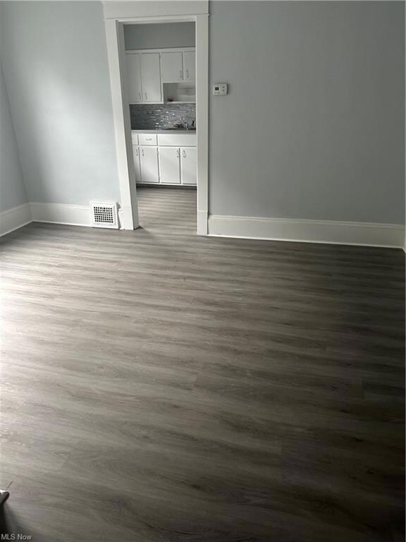 Spare room with dark wood-type flooring
