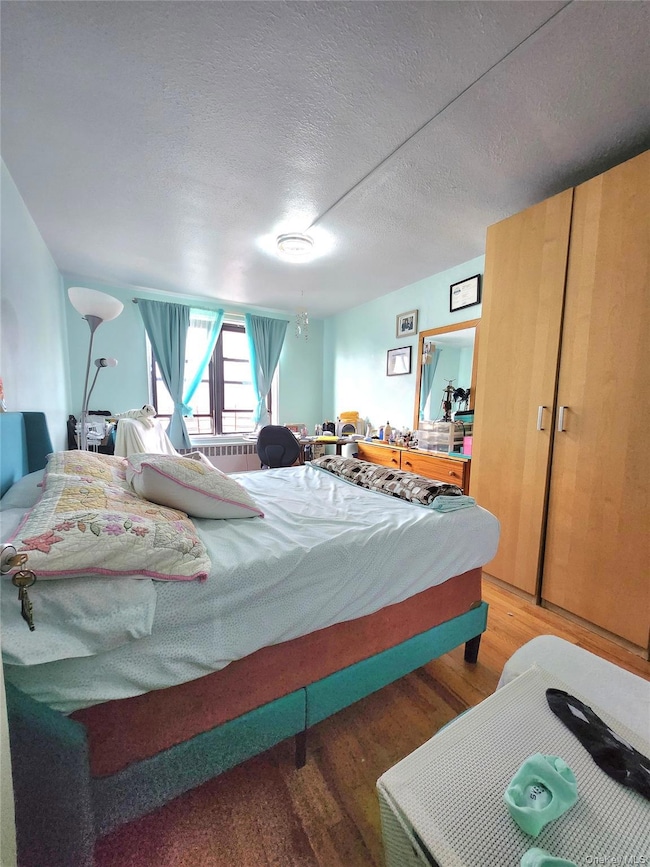 Bedroom featuring wood finished floors and a textured ceiling