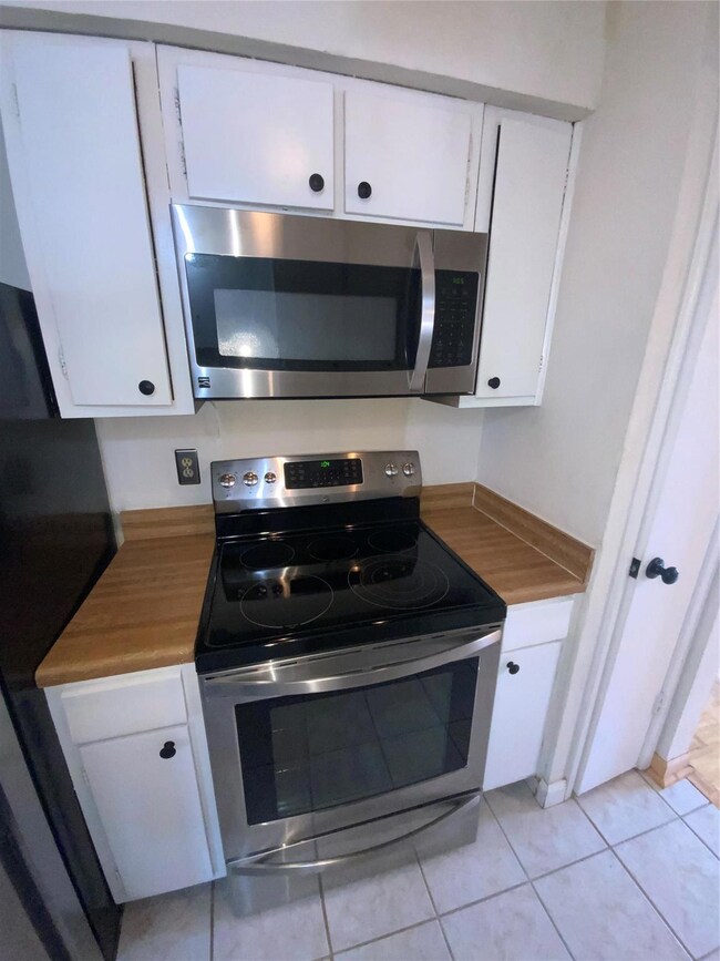 Kitchen with white cabinetry, light tile patterned