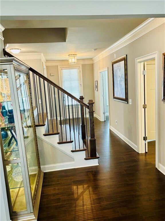 Stairway featuring ornamental molding and hardwood