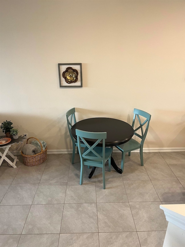 Dining room featuring light tile patterned floors and baseboards