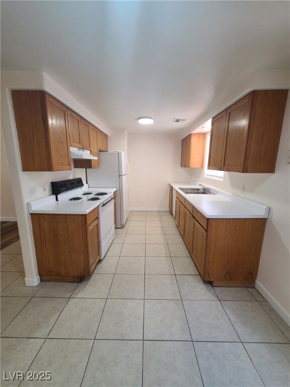 Kitchen with white appliances, light tile patterne