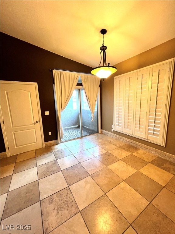 Unfurnished dining area featuring baseboards and tile patterned floors