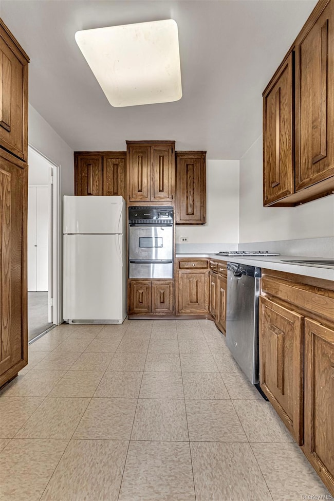 Kitchen with appliances with stainless steel finishes, sink, and light tile patterned floors