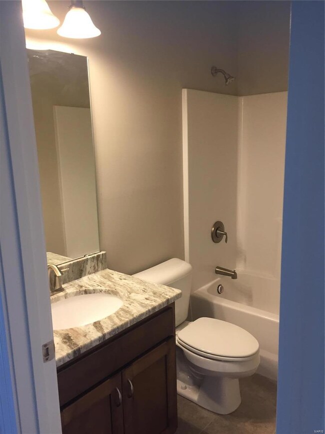 Hall bath with tile flooring, custom wood cabinet 
