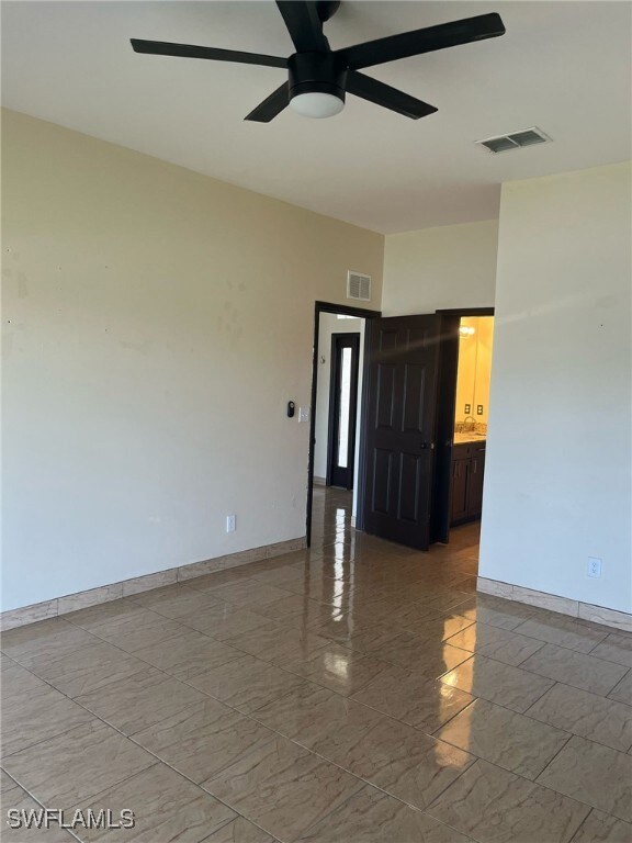 Empty room featuring ceiling fan, light marble fin