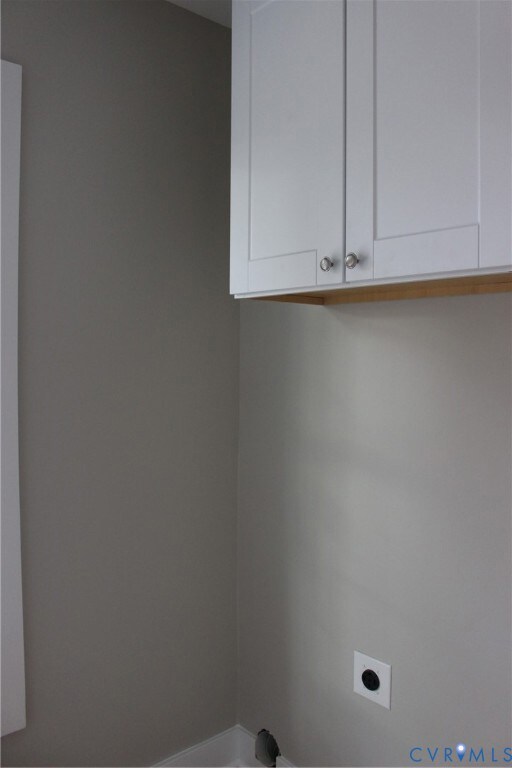 Washroom featuring cabinet space and hookup for an electric dryer