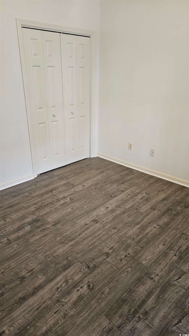Unfurnished bedroom featuring dark hardwood / wood