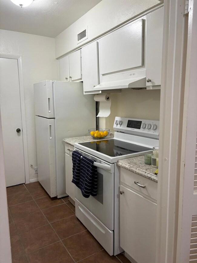 Kitchen featuring white electric stove, dark tile 