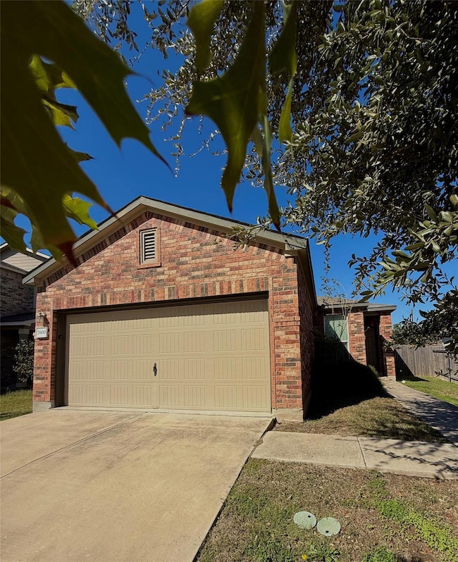 View of side of home with brick siding, driveway, and a garage