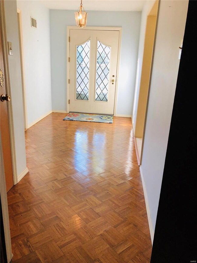 The light filled foyer has parquet flooring.