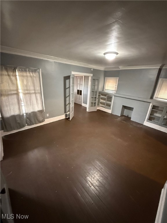 Unfurnished living room featuring ornamental molding, french doors, and dark wood-type flooring