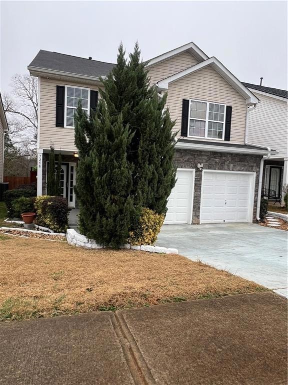 View of front facade with driveway, a garage, cent