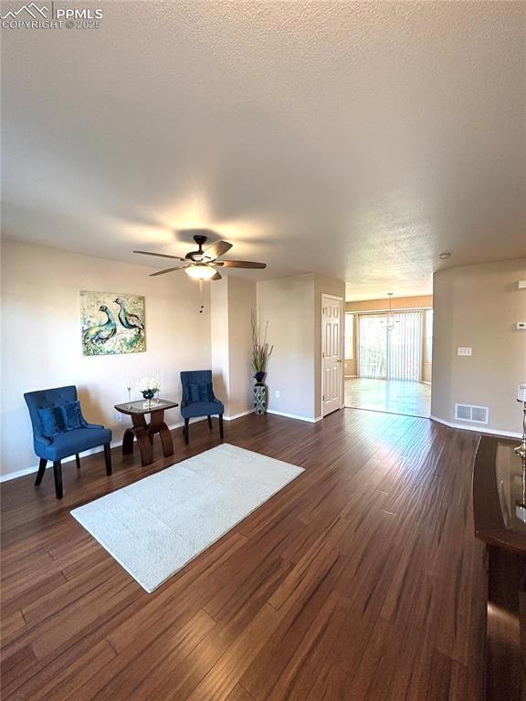 Living area featuring baseboards, a ceiling fan, d