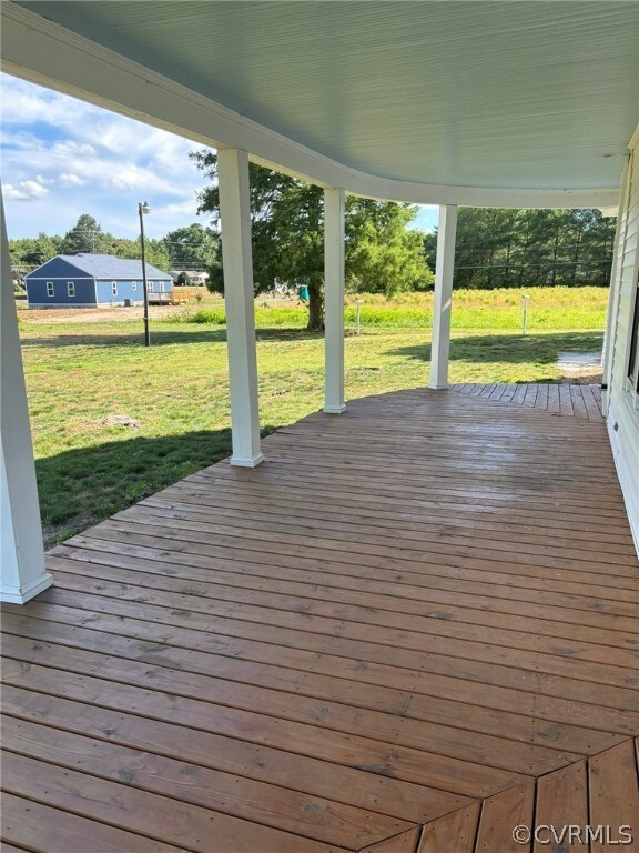Wooden terrace featuring a lawn