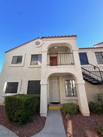 View of front of house with a balcony and stucco s