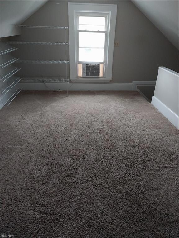 Additional living space featuring carpet floors and lofted ceiling