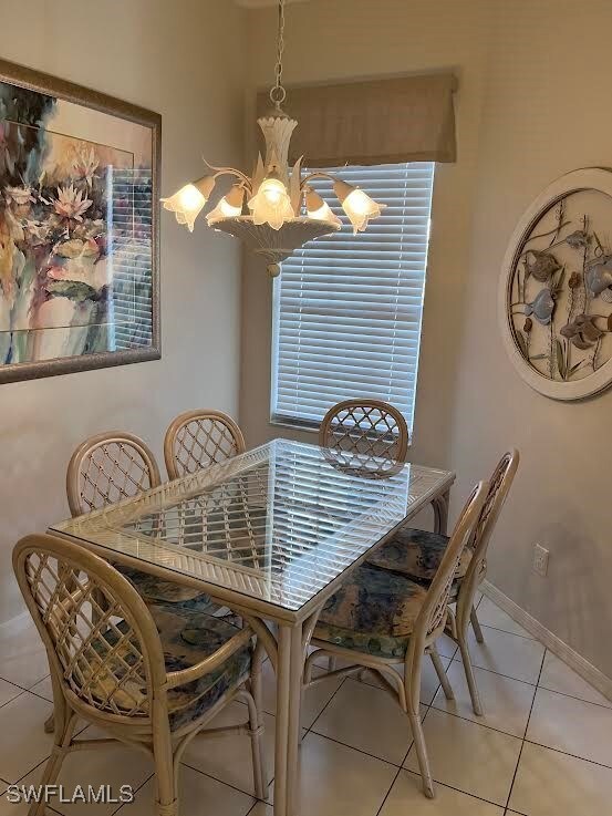 Dining space with a chandelier and light tile patt