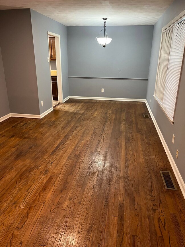 Empty room featuring dark wood finished floors and baseboards