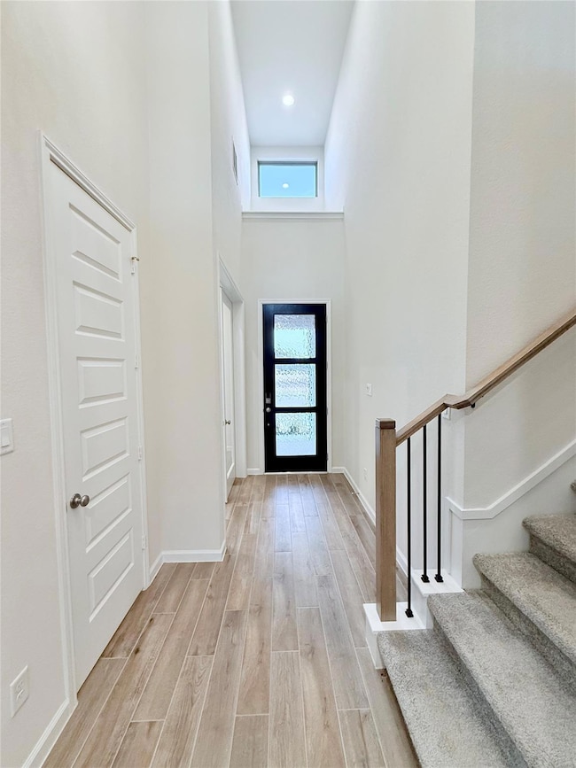 Entryway featuring light wood-style flooring, a t