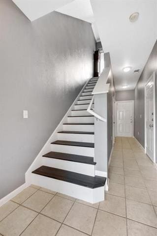 Stairway with baseboards and tile patterned floor