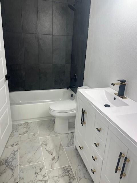 Full bathroom featuring tile patterned floors, toilet, vanity, and tiled shower / bath