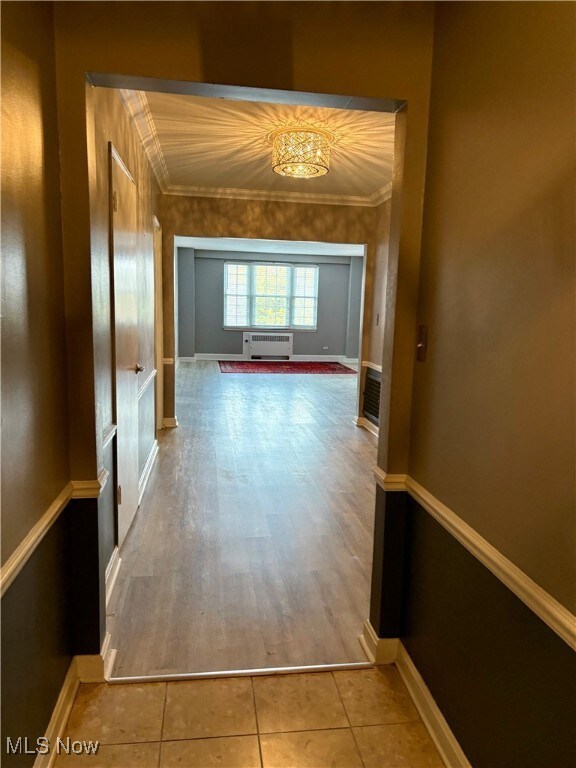 Hall with ornamental molding and light tile patterned floors