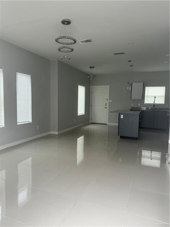 Spare room with light tile flooring, a notable chandelier, and sink