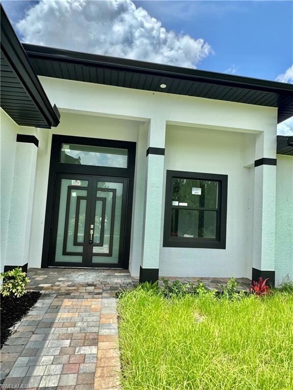 Doorway to property with stucco siding and french doors