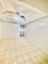 Spare room featuring light tile patterned flooring and baseboards