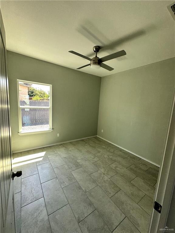 Tiled spare room with ceiling fan
