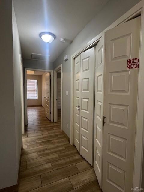 Hallway featuring dark wood-style floors and baseboards