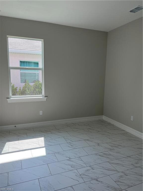 Unfurnished room with marble finish floors and bas