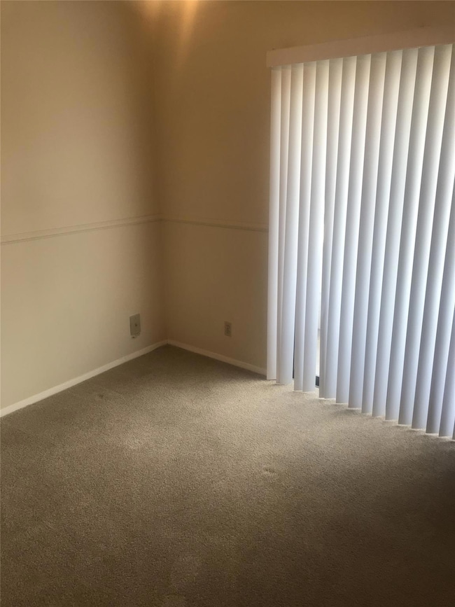 Unfurnished room with carpet floors and baseboards