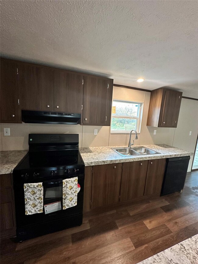 Kitchen with a textured ceiling, black range with 