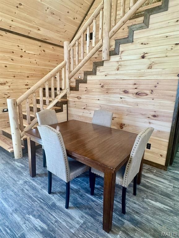 Dining area with stairs, wooden walls, wooden ceiling, and dark wood-style flooring