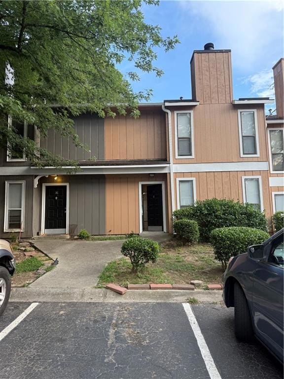 View of front of home with uncovered parking and a chimney